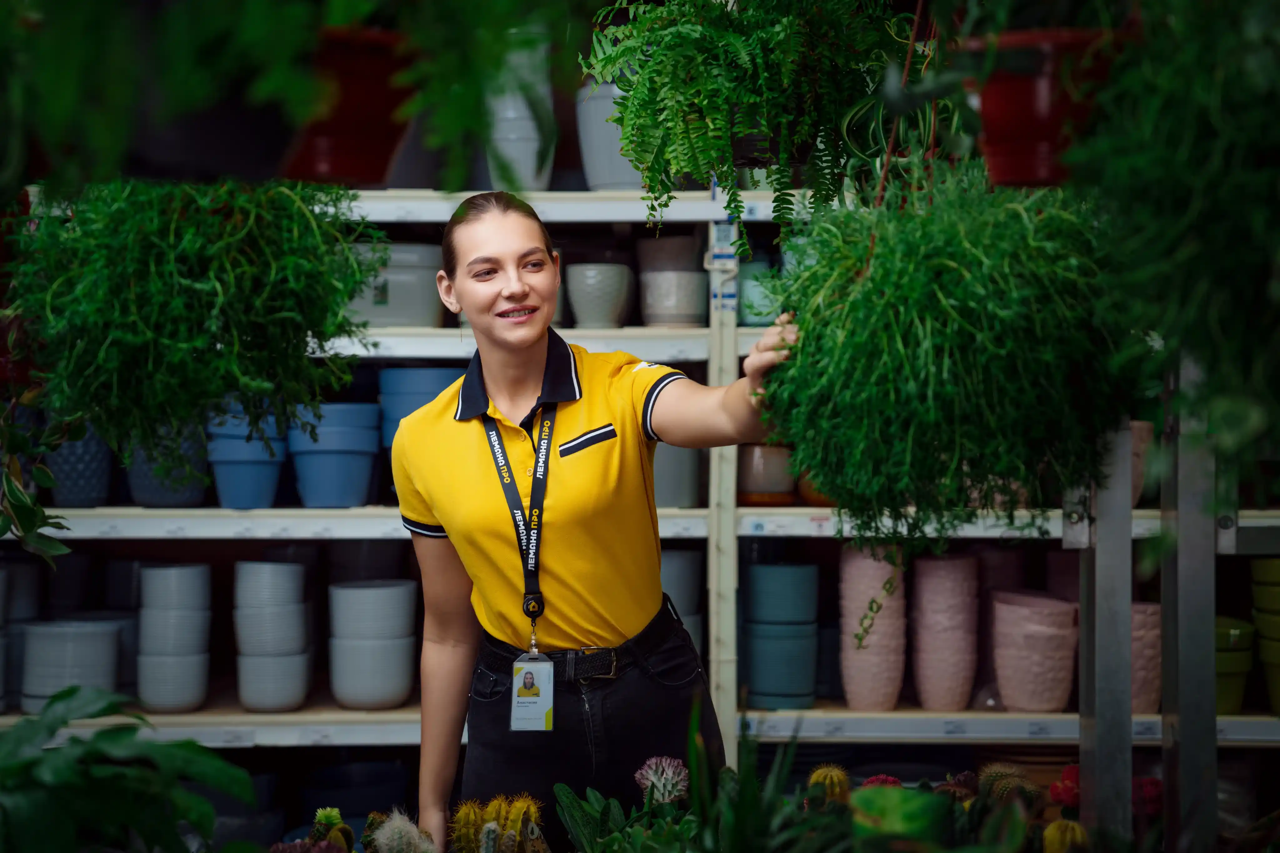 Сотрудник в желтой форме с растениями